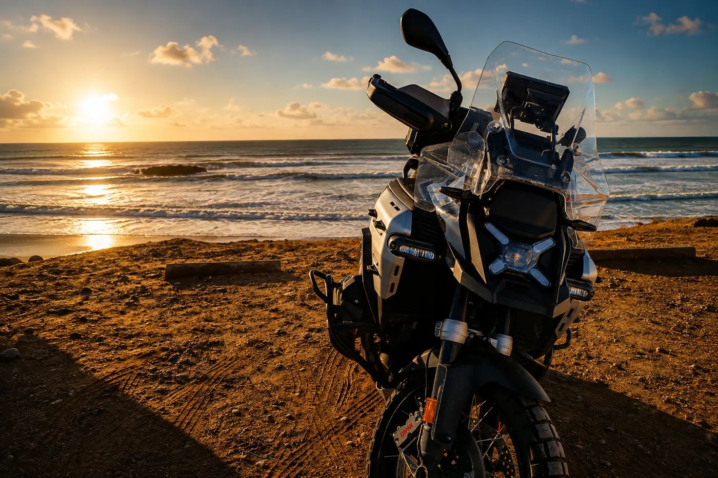 La GS 1300 Adventure de face sur le sable, face à l'océan au soleil couchant